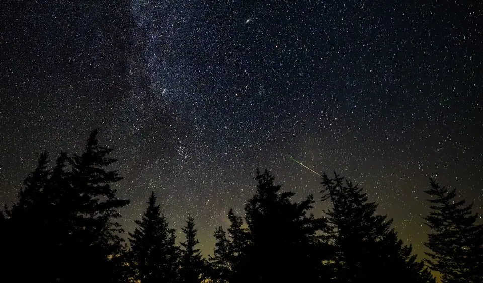 Vários meteoros registrados em longa exposição contra o fundo estrelado da Via Láctea