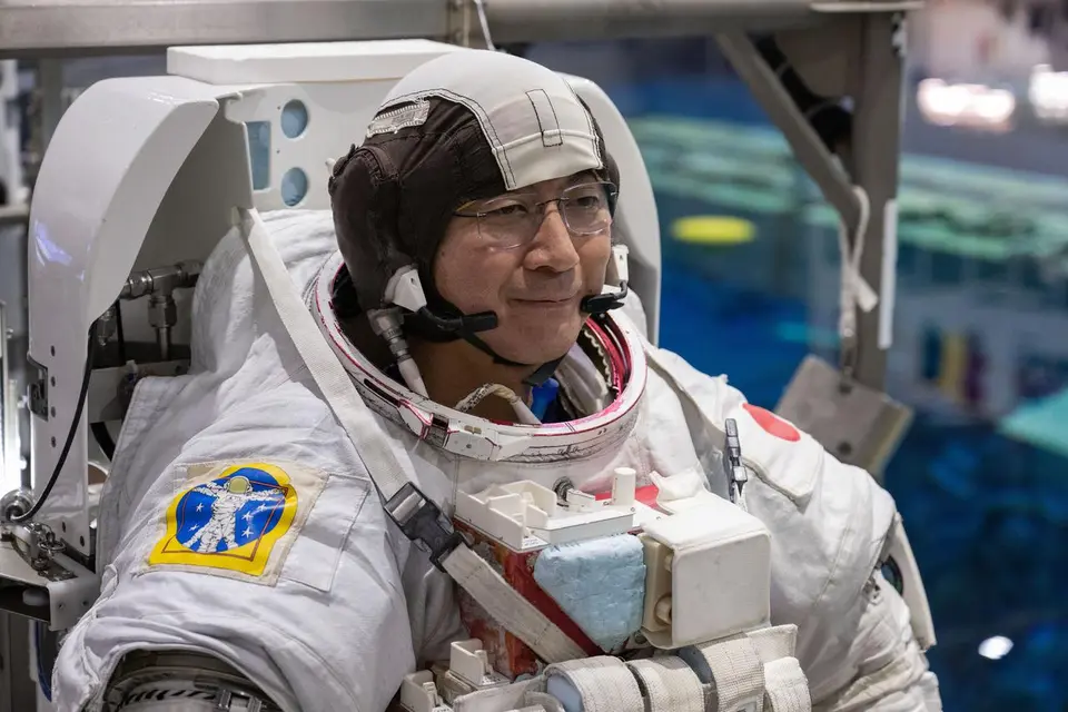 Astronauta em treinamento flutuando dentro de um módulo da Estação Espacial