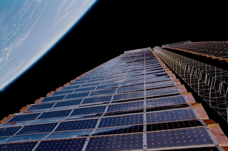 Estação Espacial Internacional vista de uma nave que se aproxima, com painéis solares dourados abertos