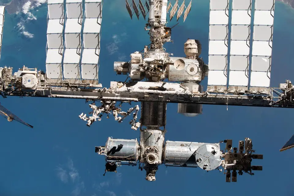 Estação Espacial Internacional fotografada do espaço com a Terra azul ao fundo