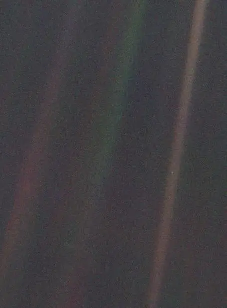 A Terra como um minúsculo ponto azul em um raio de luz solar, fotografada pela Voyager 1 a 6 bilhões de km