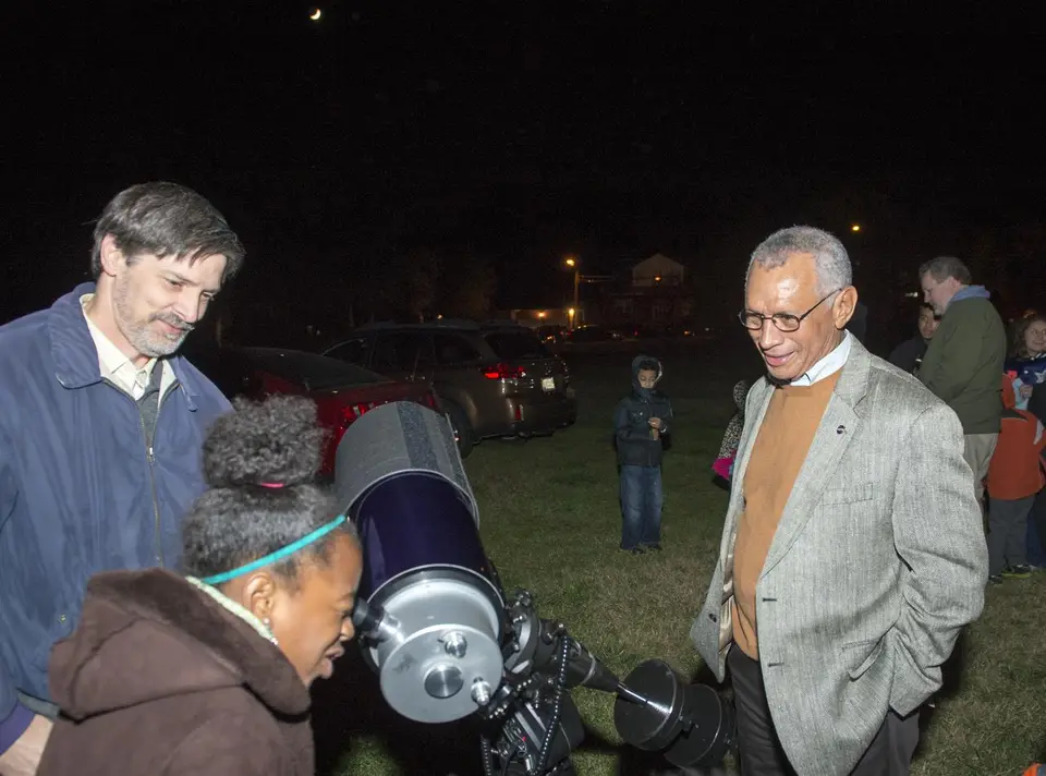 Pessoas olhando pelo telescópio durante uma observação pública noturna