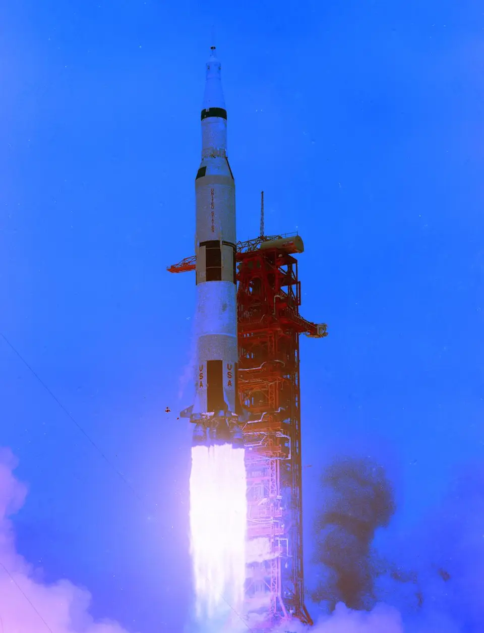 Foguete Saturn V decolando da plataforma, com a chama iluminando a fumaça