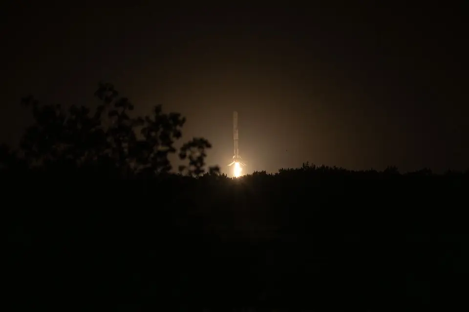 Primeiro estágio do Falcon 9 pousando em pé sobre uma plataforma com as pernas abertas