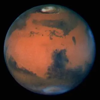 Planeta Marte visto do espaço, com a superfície alaranjada e a calota polar visível