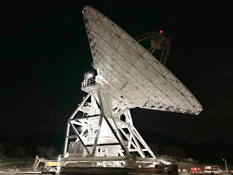 Antena parabólica de comunicação com satélites sob o céu noturno