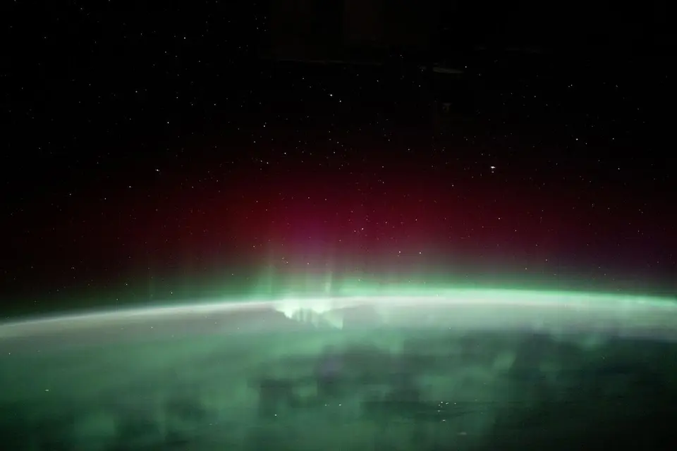 Aurora boreal verde e roxa vista da Estação Espacial Internacional sobre a Terra