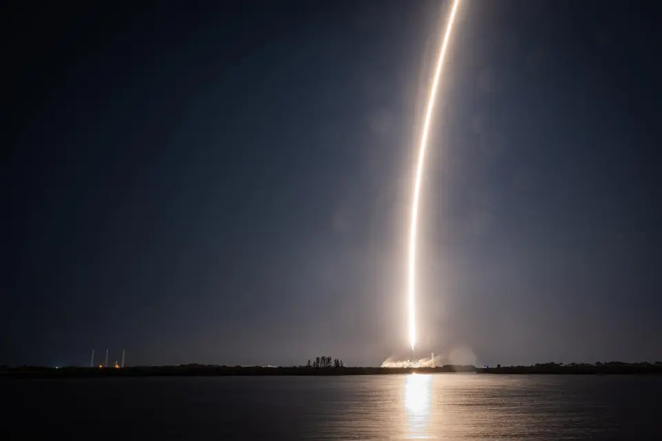 Rastro luminoso de um foguete Falcon 9 lançado à noite, registrado em longa exposição