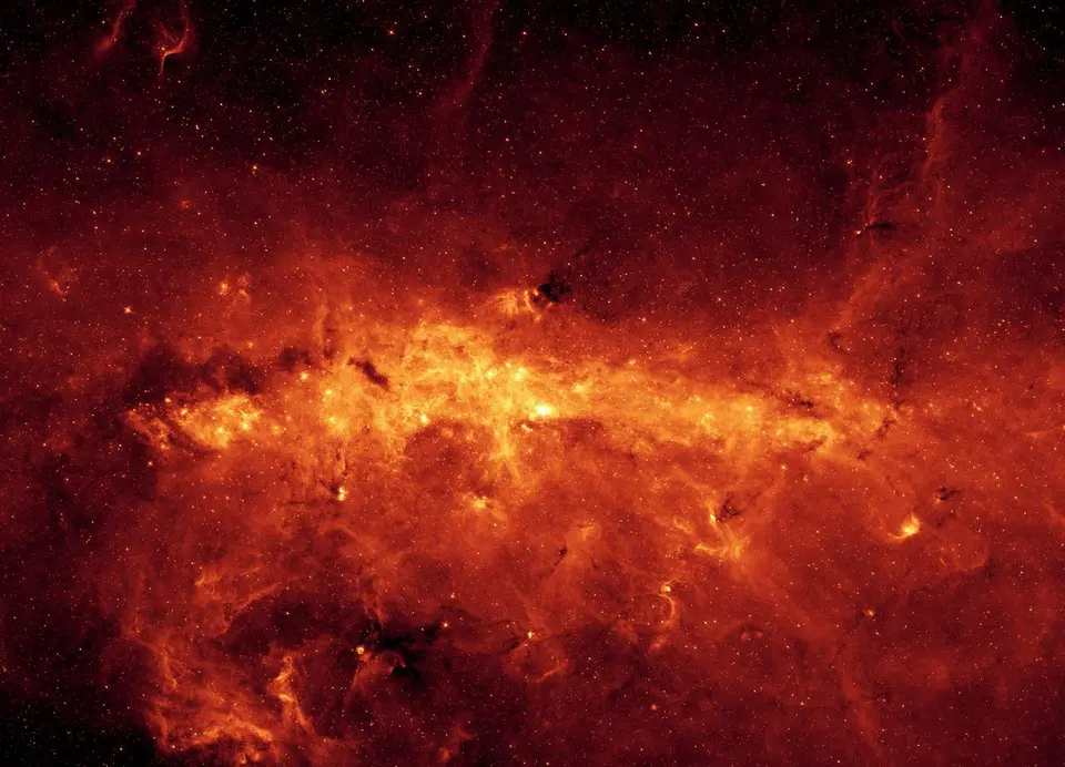 Centro da Via Láctea em infravermelho, com nuvens de poeira e milhões de estrelas